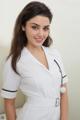 A woman in a white nurse uniform posing for a picture.