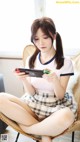 A woman sitting on a chair holding a Nintendo Switch.