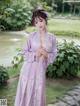 A woman in a purple kimono posing for a picture.