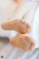 A close up of a person's bare feet on a bed.