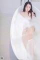 A woman is sitting in a bathtub filled with foam.