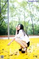 A woman sitting on the ground in a park.