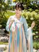 A woman in a blue and pink hanbok is posing for a picture.